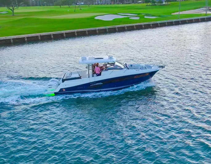  Yacht Photos Pics 2022 Jeanneau Leader 12.5 WA cruising on a serene waterway near a golf course.