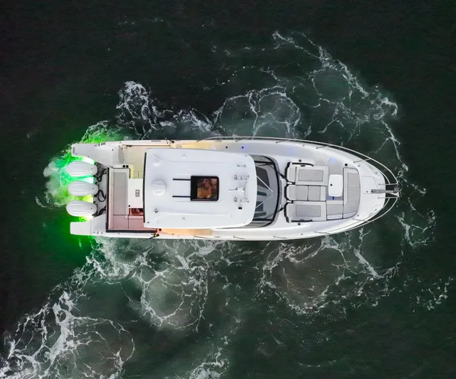  Yacht Photos Pics Aerial view of 2022 Jeanneau Leader 12.5 WA boat with green lights on water.