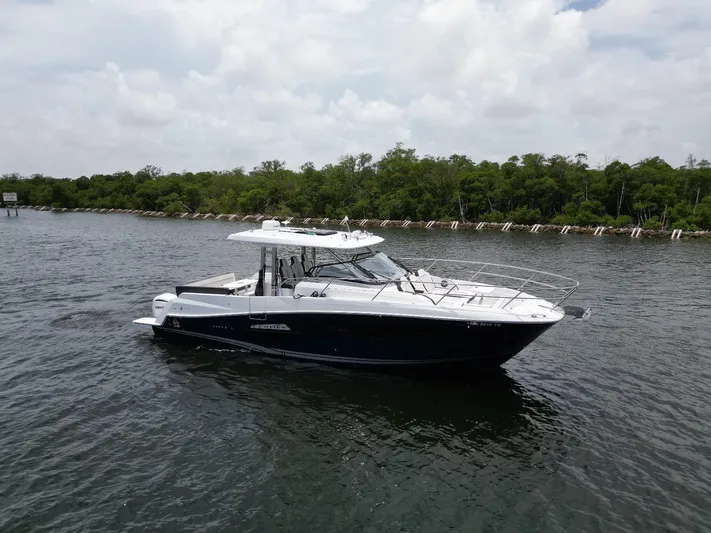  Yacht Photos Pics 2022 Jeanneau Leader 12.5 WA boat cruising on a calm river with lush greenery.