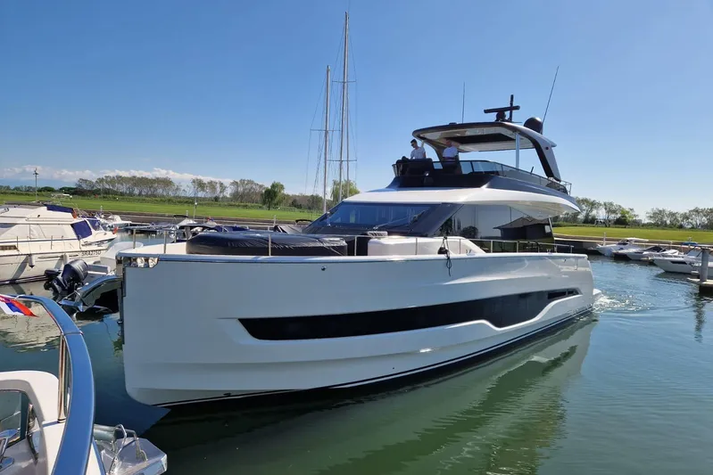  Yacht Photos Pics 2025 Cranchi Sessantadue 62 yacht docked in a marina under clear blue skies.
