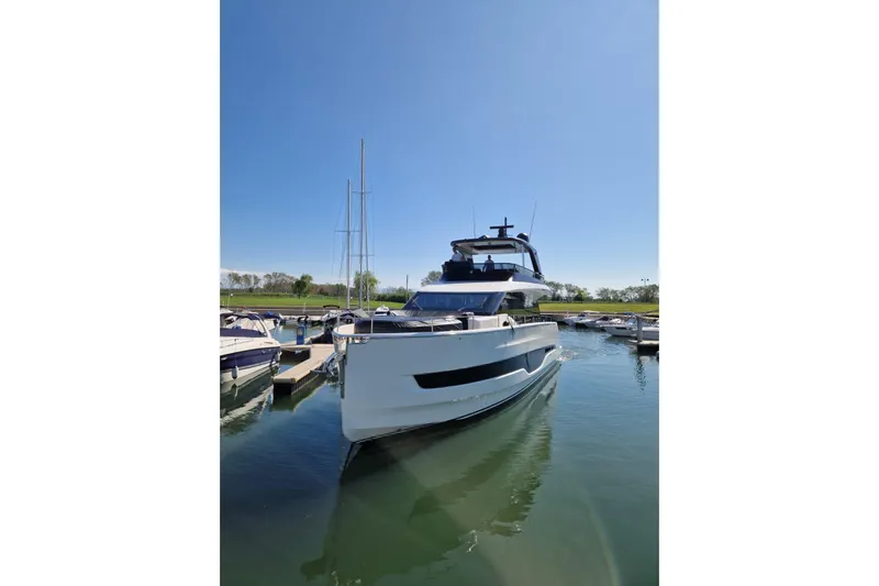 Yacht Photos Pics 2025 Cranchi Sessantadue 62 yacht docked in a marina under clear blue skies.