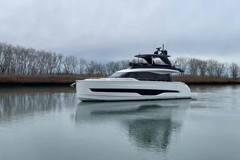  Yacht Photos Pics 2025 Cranchi Sessantadue 62 yacht on calm water, surrounded by trees.