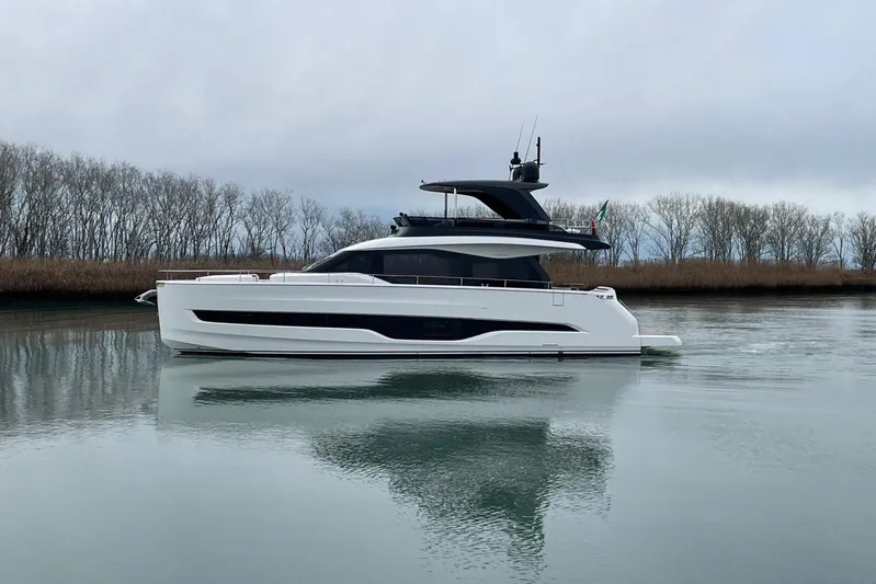  Yacht Photos Pics 2025 Cranchi Sessantadue 62 yacht on calm water, with trees in the background.