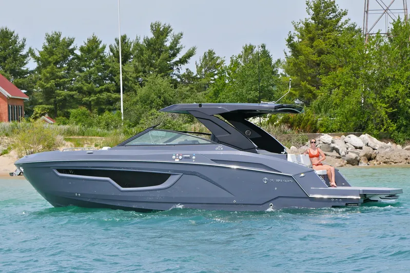  Yacht Photos Pics 2026 Cruisers Yachts 34 GLS I/O on water, sleek design, person relaxing onboard.