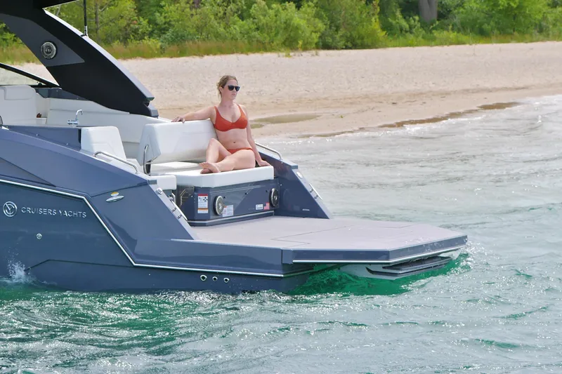  Yacht Photos Pics 2026 Cruisers Yachts 34 GLS I/O on water, woman relaxing on deck.