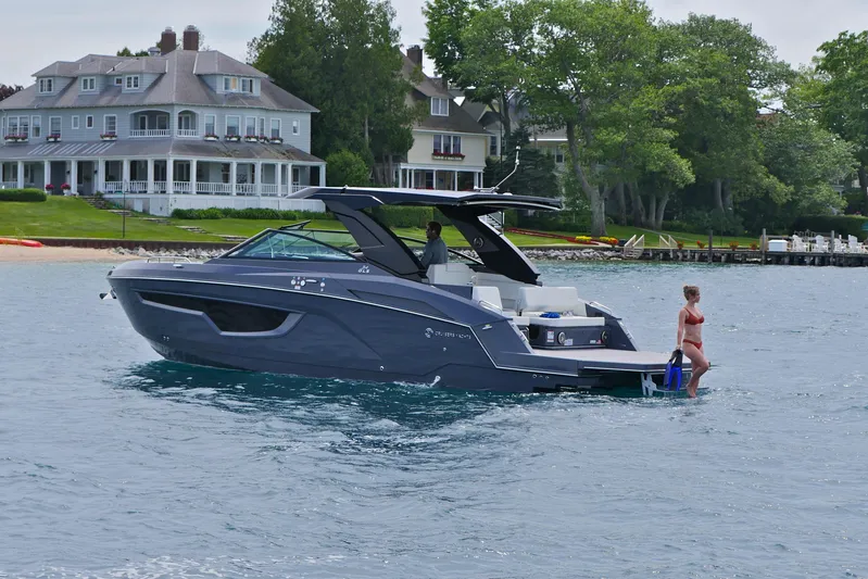  Yacht Photos Pics 2026 Cruisers Yachts 34 GLS I/O on water near luxury homes, woman entering water.