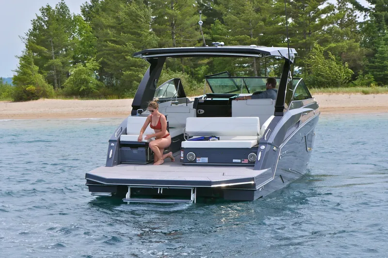  Yacht Photos Pics 2026 Cruisers Yachts 34 GLS I/O on water near a sandy beach.