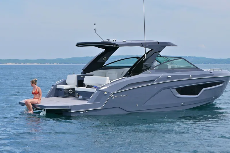  Yacht Photos Pics 2026 Cruisers Yachts 34 GLS I/O on water with person sitting on swim platform.