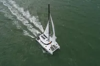 Aerial view of 2025 Nautitech 44 Open catamaran sailing on open water.