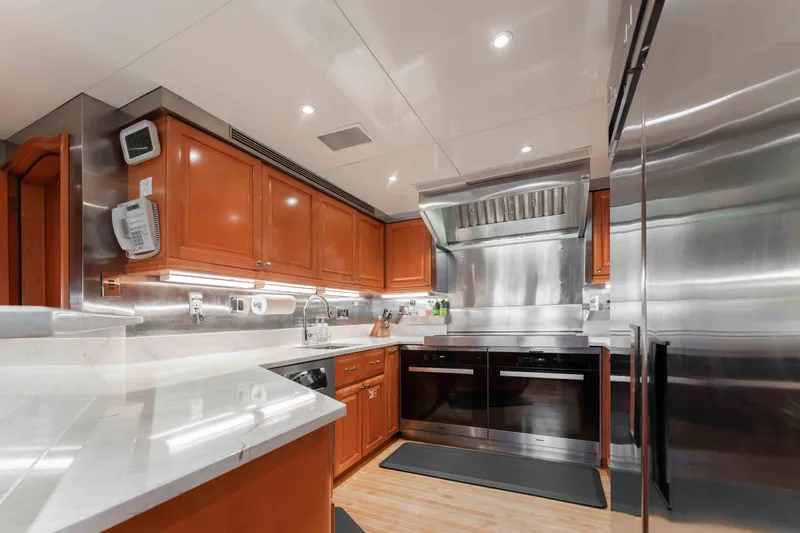 Summerdance Yacht Photos Pics Luxurious kitchen in 2004 Trinity Yachts motor yacht with modern appliances and wooden cabinetry.