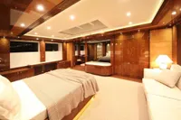 Luxurious bedroom interior on 2014 Bilgin Custom 150 yacht, featuring elegant wood paneling and ambient lighting.