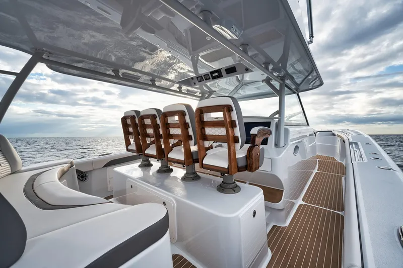  Yacht Photos Pics 2022 Yellowfin 54 Offshore boat interior with wooden seats and ocean view.