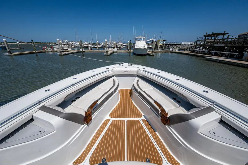  Yacht Photos Pics 2022 Yellowfin 54 Offshore boat docked at marina, featuring spacious deck and seating.