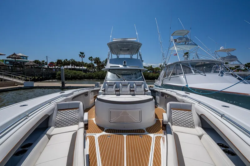  Yacht Photos Pics 2022 Yellowfin 54 Offshore boat with luxurious seating and sleek design at a marina.
