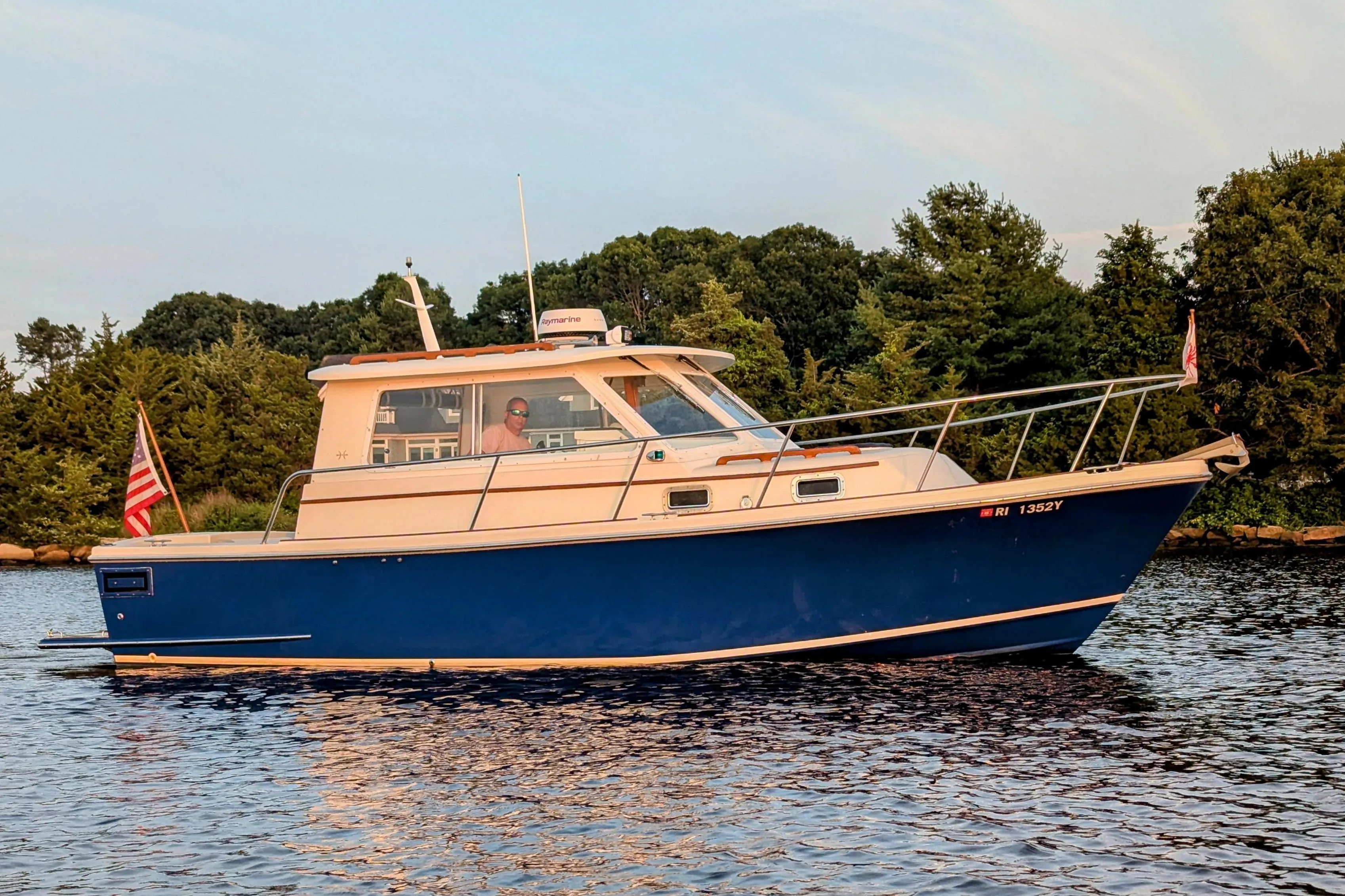 2000 Hunt Yachts 28 Express cruising on calm water, surrounded by lush greenery.