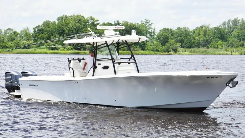  Yacht Photos Pics 2014 Regulator 34 boat cruising on a river with lush green trees in the background.