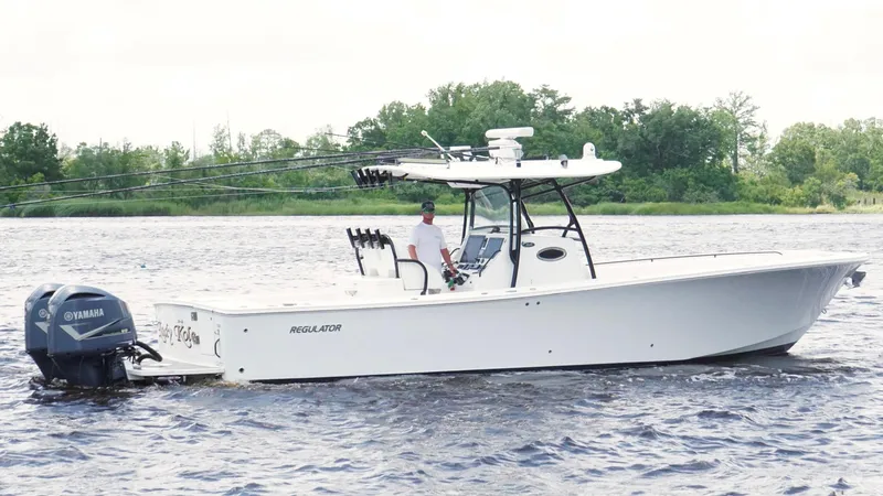  Yacht Photos Pics 2014 Regulator 34 boat on water with Yamaha engines, surrounded by trees.