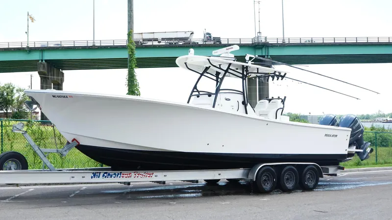  Yacht Photos Pics 2014 Regulator 34 boat on trailer, parked near a bridge.