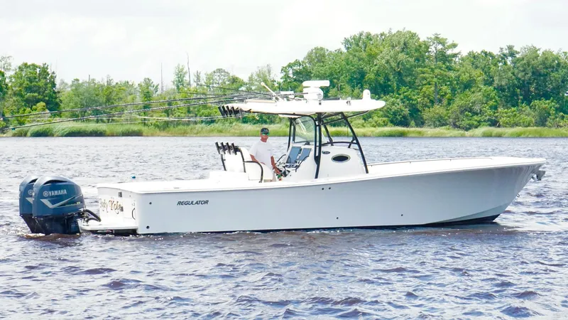  Yacht Photos Pics 2014 Regulator 34 boat on water with Yamaha engines, surrounded by lush greenery.