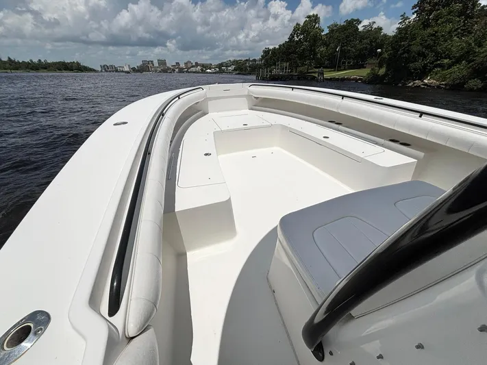  Yacht Photos Pics 2014 Regulator 34 boat interior with seating, on a scenic waterway under a cloudy sky.