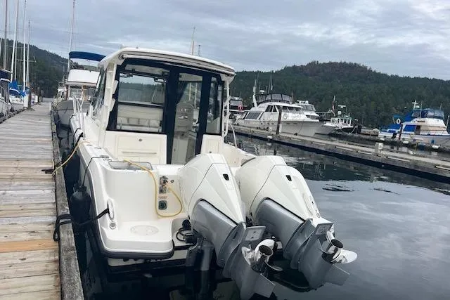  Yacht Photos Pics 2020 Boston Whaler 325 Conquest docked, featuring dual outboard engines, in a marina setting.