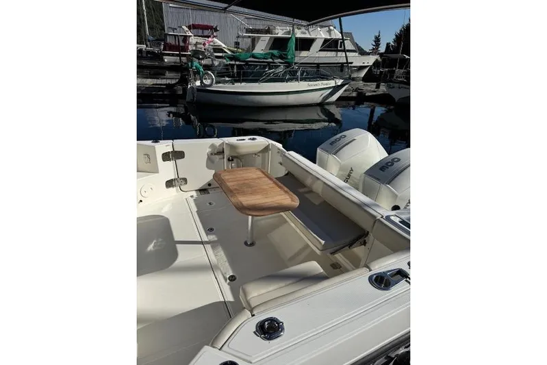  Yacht Photos Pics 2020 Boston Whaler 325 Conquest boat interior with wooden table and dual engines.