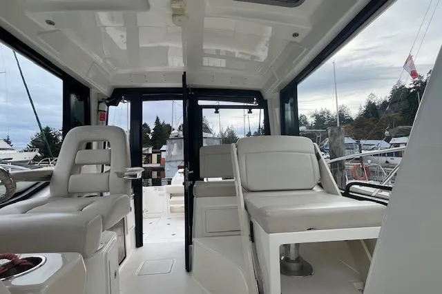  Yacht Photos Pics 2020 Boston Whaler 325 Conquest interior with seating and helm, docked at marina.