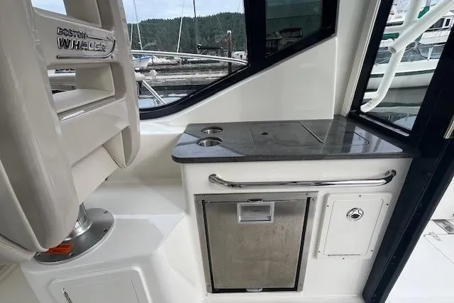  Yacht Photos Pics 2020 Boston Whaler 325 Conquest interior with sleek countertop and storage, docked at marina.
