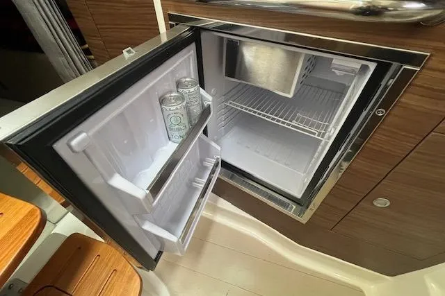 Yacht Photos Pics Open mini fridge on 2020 Boston Whaler 325 Conquest boat, containing canned beverages.
