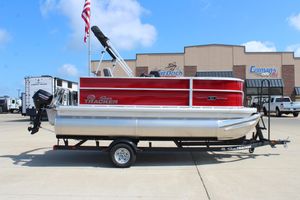 2026 Sun Tracker Party Barge 16 DLX pontoon boat on trailer, parked at dealership.