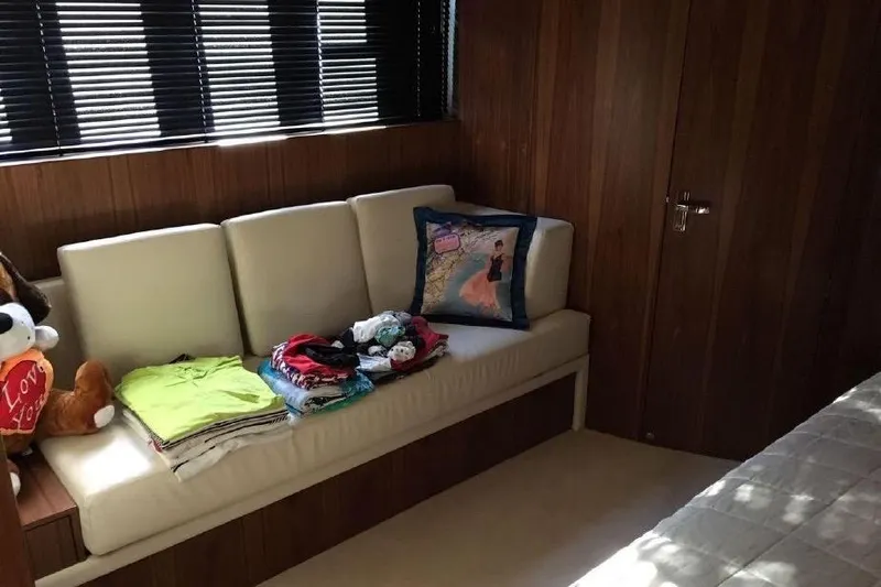 Gala Yacht Photos Pics Interior of 2012 Fsirline Squadron 78 yacht with sofa, cushions, and folded clothes.