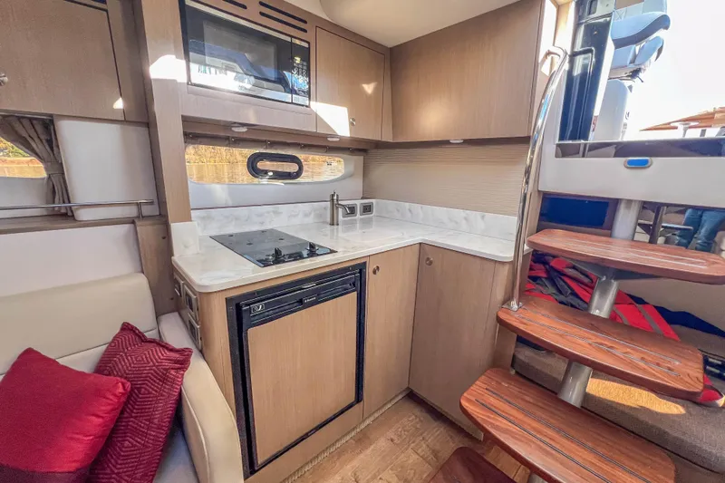  Yacht Photos Pics Interior of 2018 Sea Ray Sundancer 350 Coupe, featuring modern kitchen and wooden stairs.