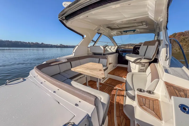  Yacht Photos Pics 2018 Sea Ray Sundancer 350 Coupe interior with seating and table on calm water.