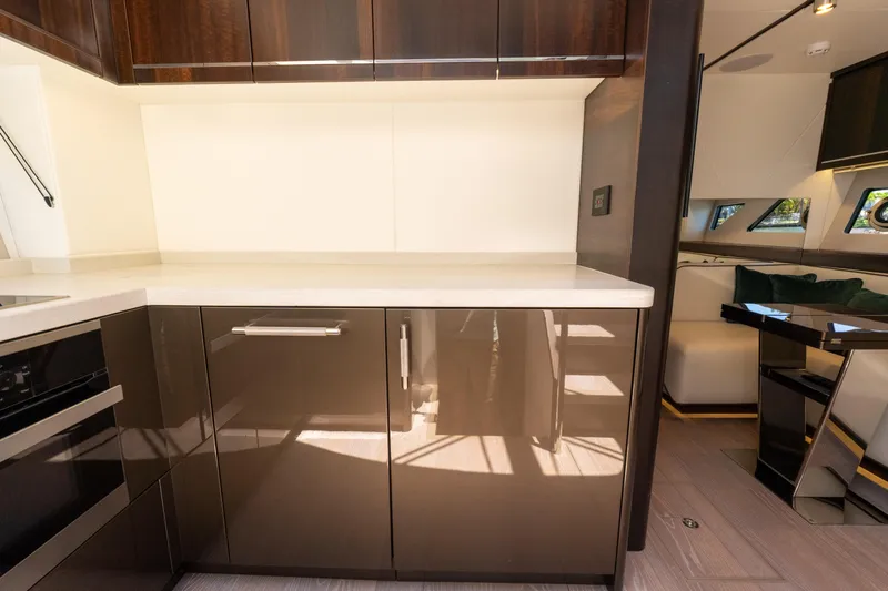 Brew Crew Yacht Photos Pics Luxurious Sunseeker Predator 60 yacht interior, featuring modern kitchen cabinetry and sleek design, 2022 model.