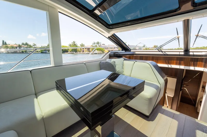 Brew Crew Yacht Photos Pics Luxurious interior of 2022 Sunseeker Predator 60 yacht with sleek seating and waterfront view.