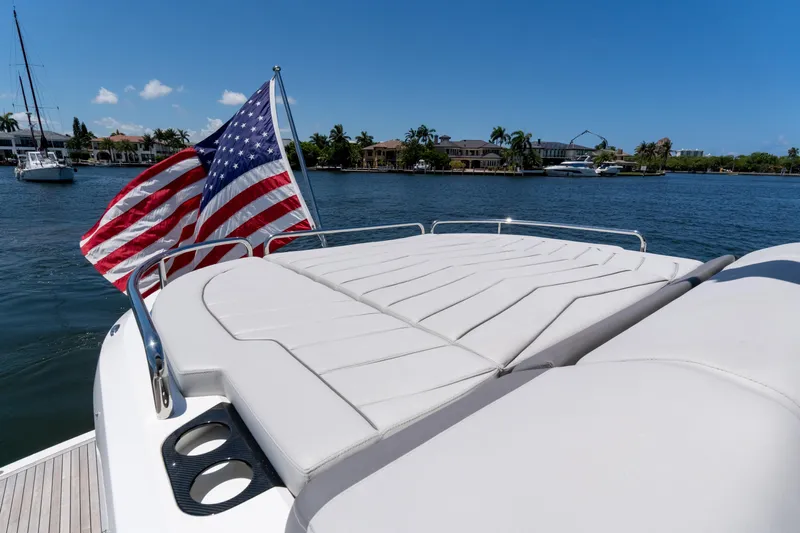Brew Crew Yacht Photos Pics Sunseeker Predator 60 yacht, 2022 model, with American flag, on a sunny day by the water.