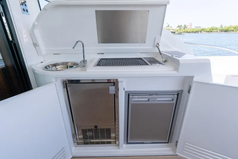 Brew Crew Yacht Photos Pics Outdoor kitchenette on 2022 Sunseeker Predator 60 yacht with sink, grill, and storage.