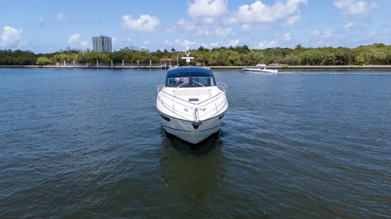 Brew Crew Yacht Photos Pics 2022 Sunseeker Predator 60 yacht on calm water, clear sky, and distant shoreline.