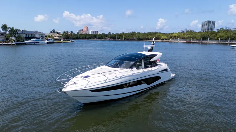Brew Crew Yacht Photos Pics 2022 Sunseeker Predator 60 yacht cruising on a sunny day in a scenic waterway.