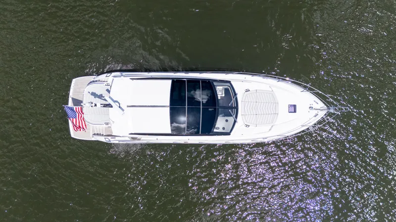 Brew Crew Yacht Photos Pics Aerial view of 2022 Sunseeker Predator 60 yacht on water, displaying sleek design and American flag.