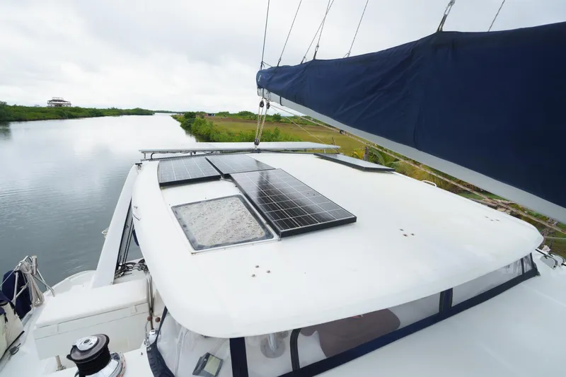Dreaming On Yacht Photos Pics Sailboat with solar panels on deck, Leopard 47 model, 2003, cruising along a serene waterway.