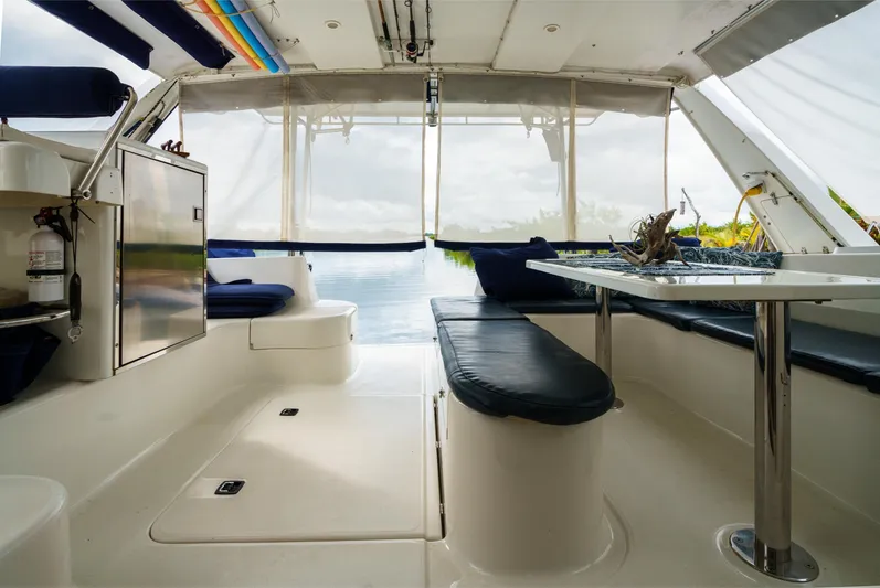 Dreaming On Yacht Photos Pics Interior of 2003 Leopard 47 catamaran with seating and table, overlooking water.