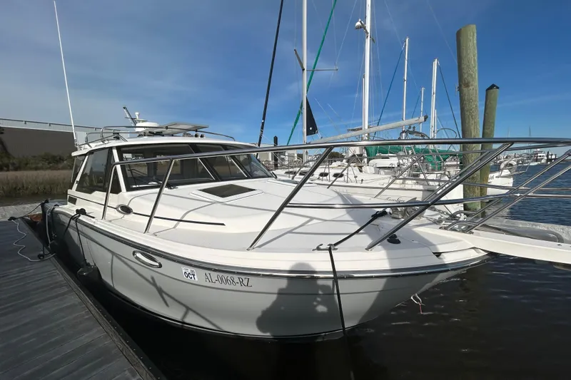  Yacht Photos Pics 2024 Cutwater C-288 Coupe boat docked at marina under clear blue sky.