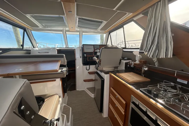  Yacht Photos Pics 2024 Cutwater C-288 Coupe interior with helm, kitchen, and seating area.