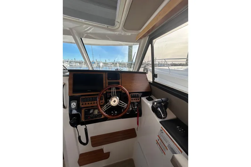  Yacht Photos Pics 2024 Cutwater C-288 Coupe helm with wooden dashboard and modern controls.
