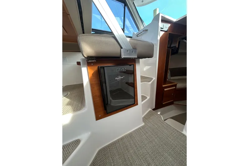  Yacht Photos Pics 2024 Cutwater C-288 Coupe interior with compact fridge and seating area.