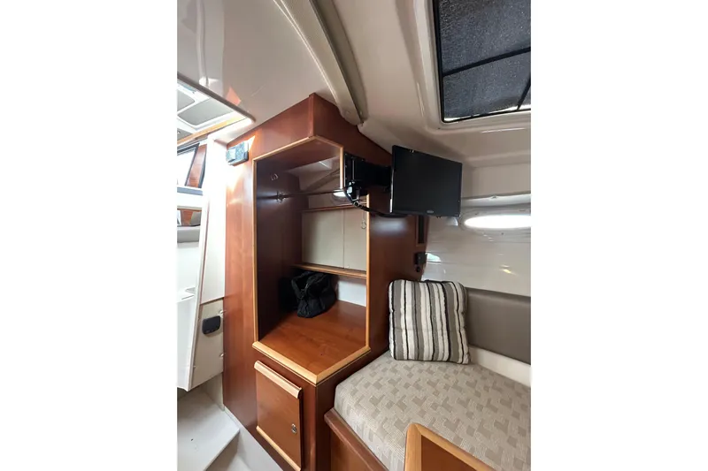  Yacht Photos Pics 2024 Cutwater C-288 Coupe interior with wood cabinetry, TV, and cozy seating area.