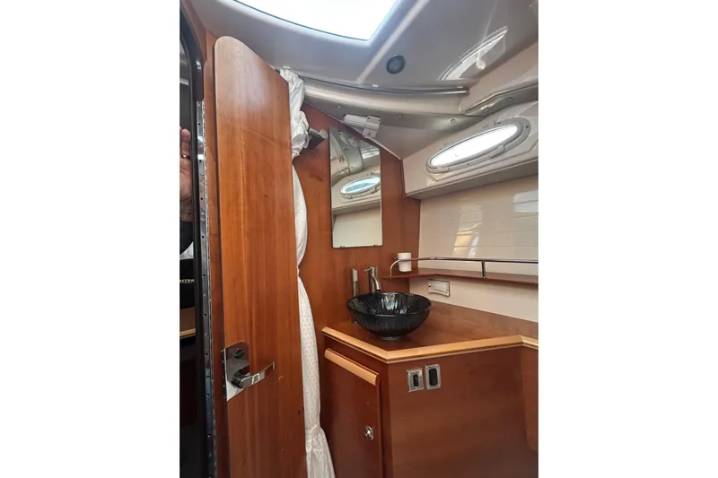  Yacht Photos Pics 2024 Cutwater C-288 Coupe interior bathroom with wooden cabinetry and modern sink design.