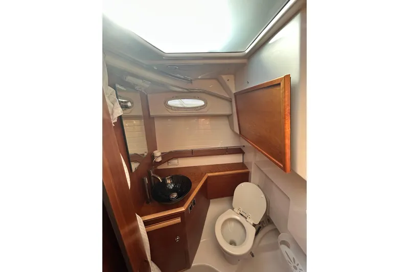  Yacht Photos Pics 2024 Cutwater C-288 Coupe bathroom with wooden accents and modern fixtures.