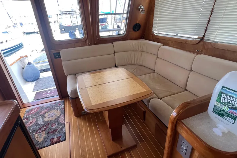  Yacht Photos Pics Interior of 2005 Sabre Flybridge yacht with beige seating and wooden table.